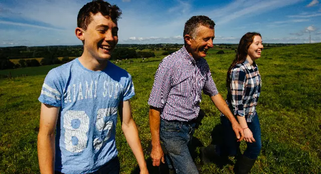 people walking through field